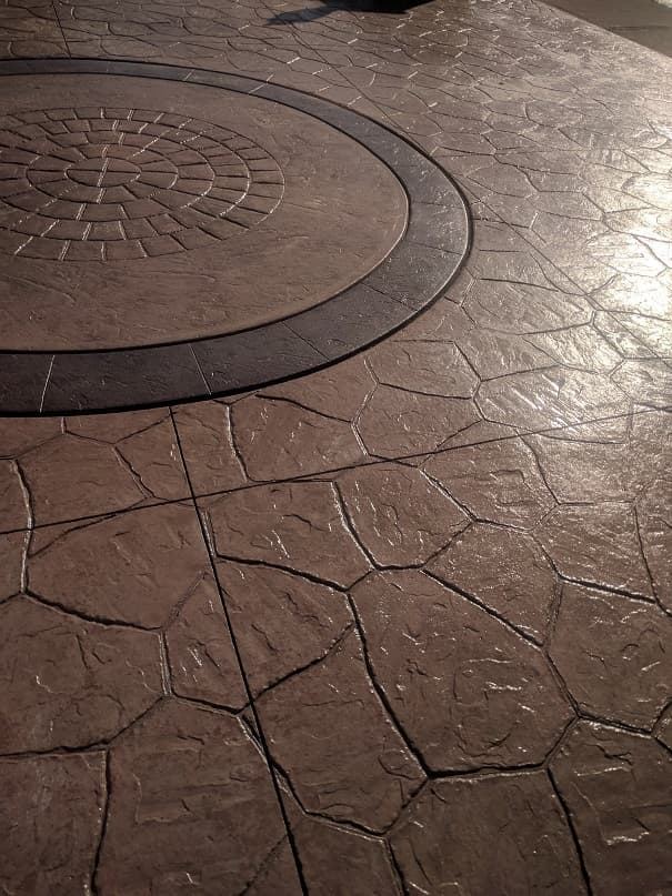 Stamped concrete patio with circular medallion in brown tones