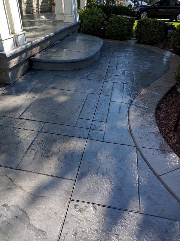 Stamped concrete patio in slate grey with curved edge