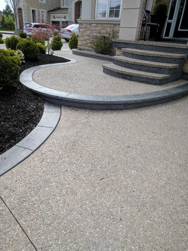 Curved exposed aggregate walkway with garden border