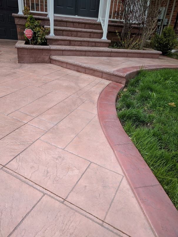 Stamped concrete walkway in terracotta with curved lawn edge